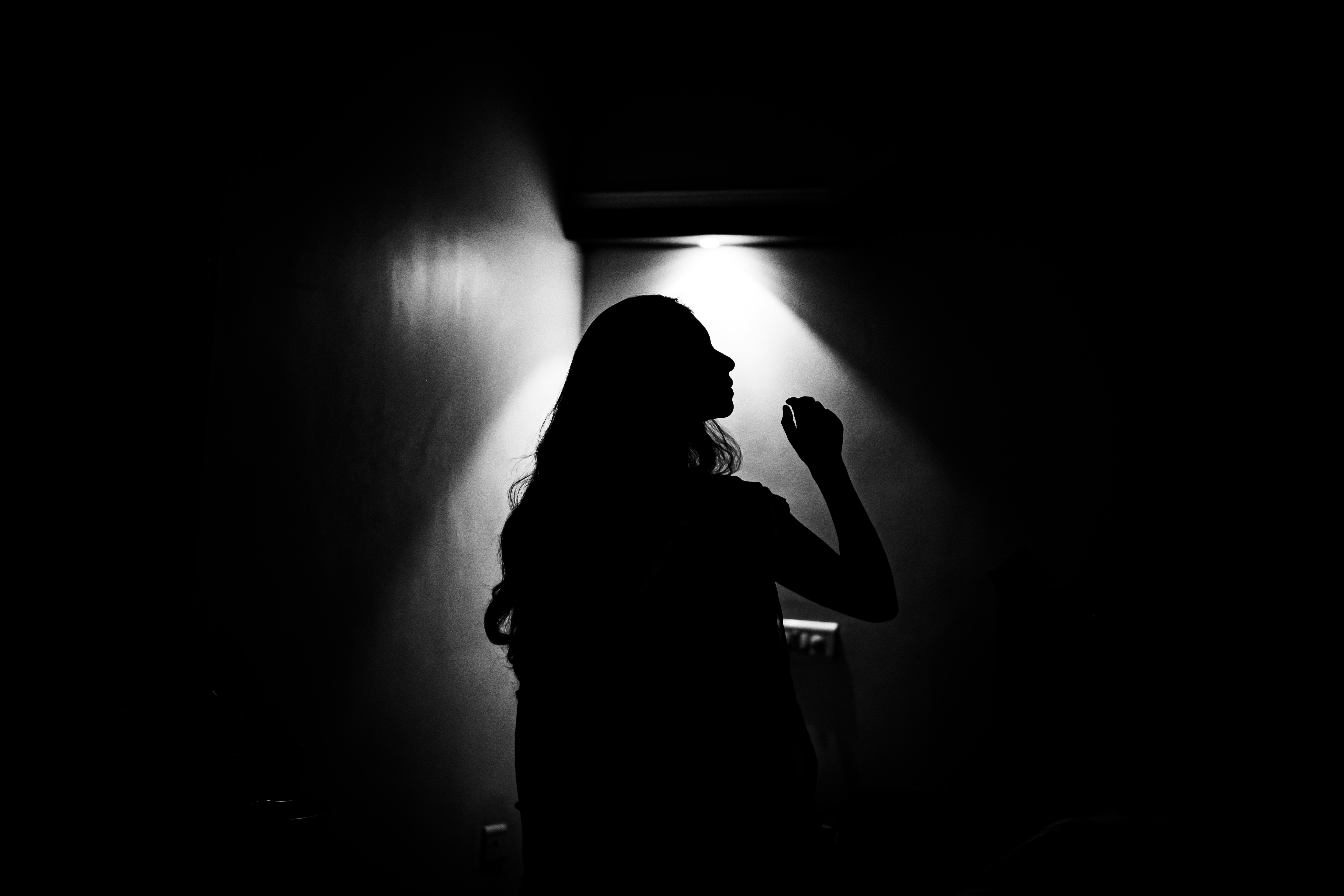 silhouette of woman in dark room